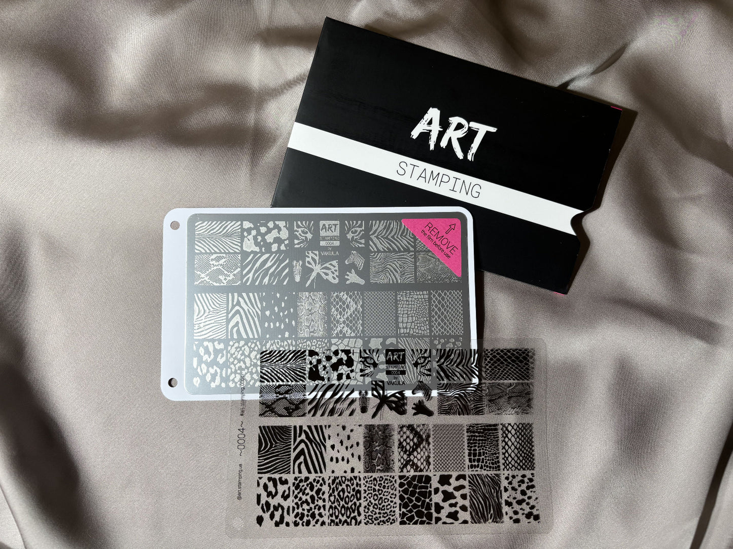 Two stencils with various patterns and a black box labeled 'STAMPS' on a light fabric background.