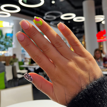 Close-up of a hand with colorful nail polish in an indoor setting
