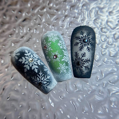 Three nail art designs with snowflakes on a textured surface