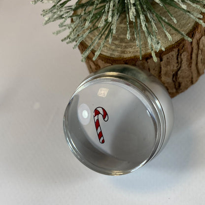 Clear glass ornament with a candy cane design on a white background