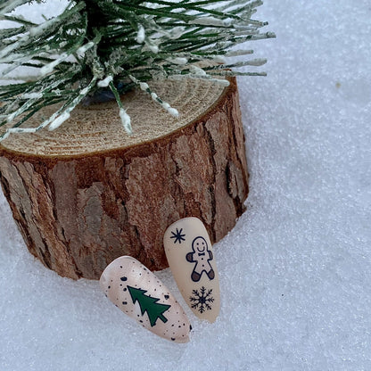 Two decorative stones with winter-themed designs on a snowy background