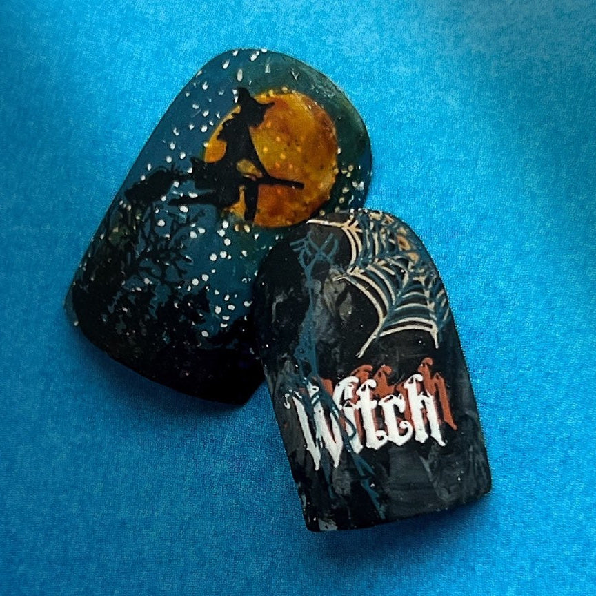 Halloween-themed nail tips on a blue background