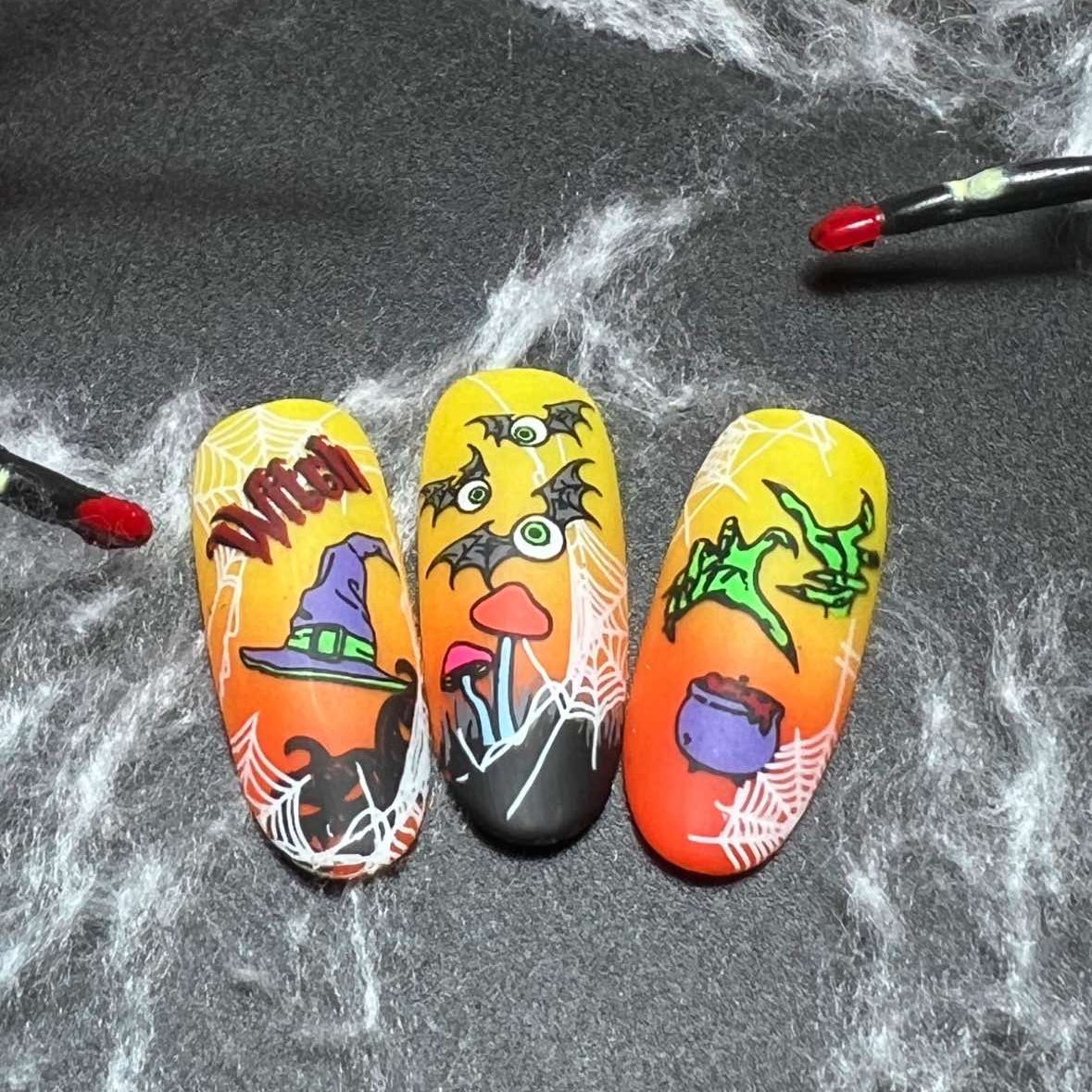 Halloween-themed nail art designs on a dark surface with a spider web.