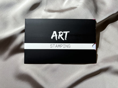 Black box with 'STAMPING ART' text on a light fabric background