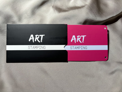 Two art stamping tools with black, red, and white design on a gray fabric background.
