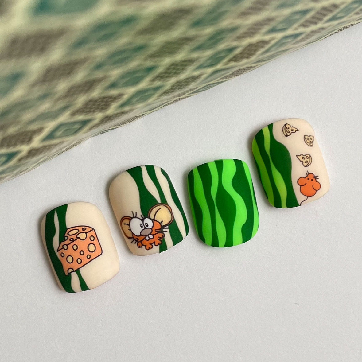 Four nails with cartoon designs on a white surface