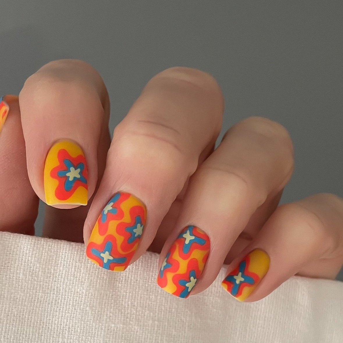 Nails with colorful abstract design on a neutral background