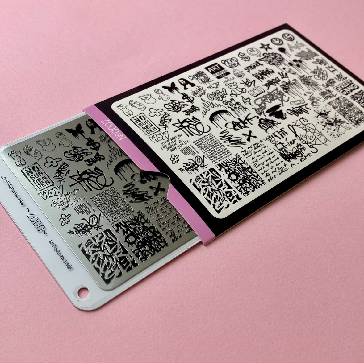 Two nail art stamping plates with black designs on a pink background