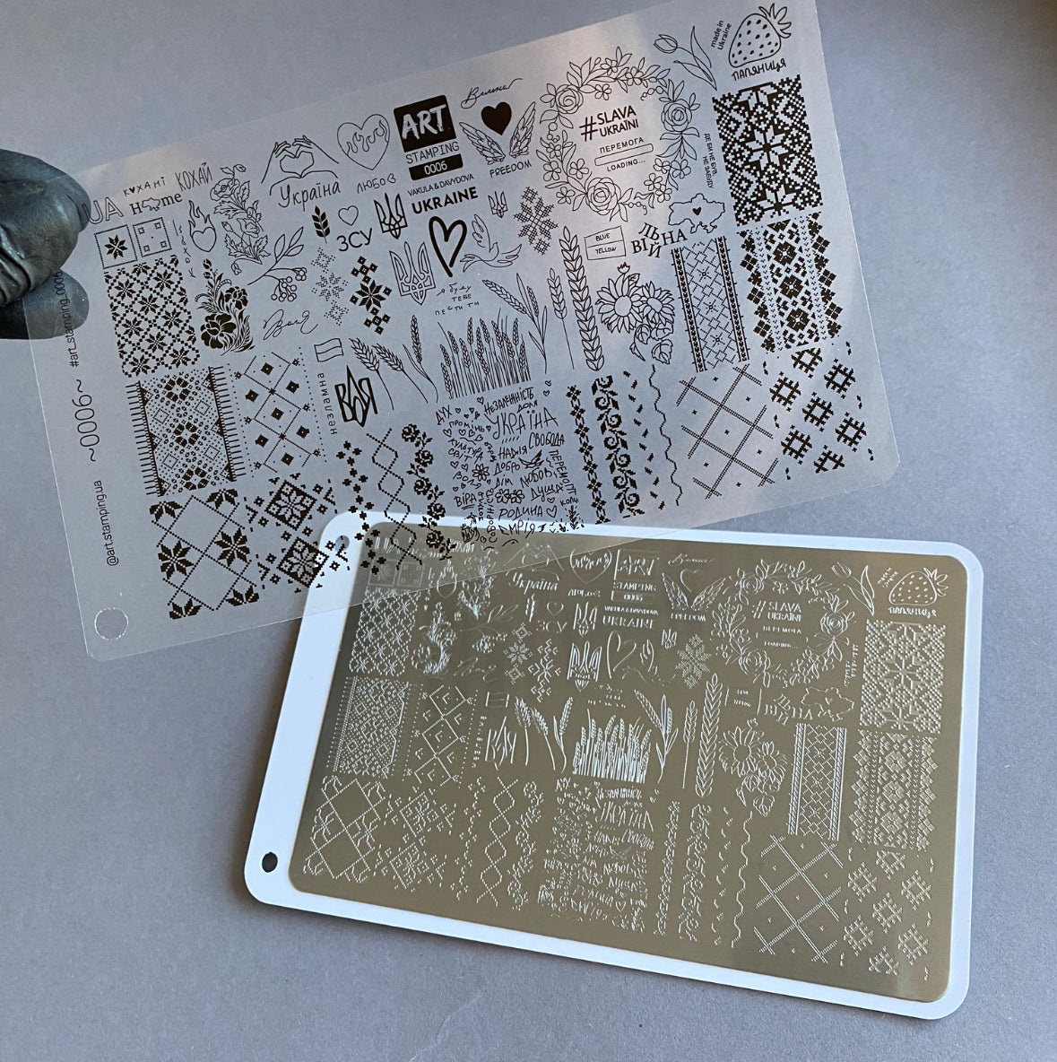 Two stencils with various designs on a gray surface