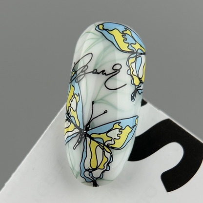 Decorative die with a blue and yellow butterfly design on a gray background